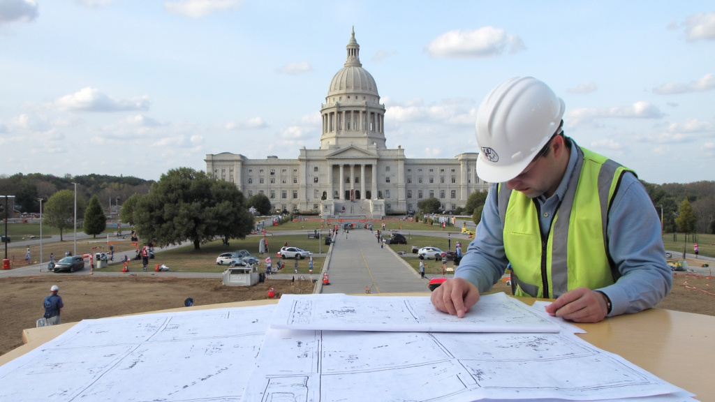 Texas State Capitol Building Construction Texas state capitol building with construction site in foreground, inspector reviewing blueprints