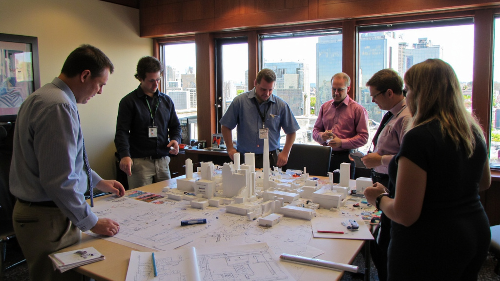 Architects and Engineers Collaboration A team of architects and engineers collaborating over blueprints and energy efficiency models in a Texas-style office.