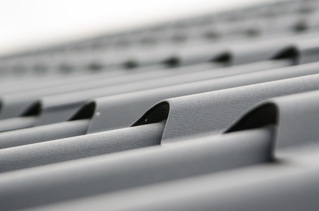 Close-up of a gray metal roof with corrugated panels in focus.
