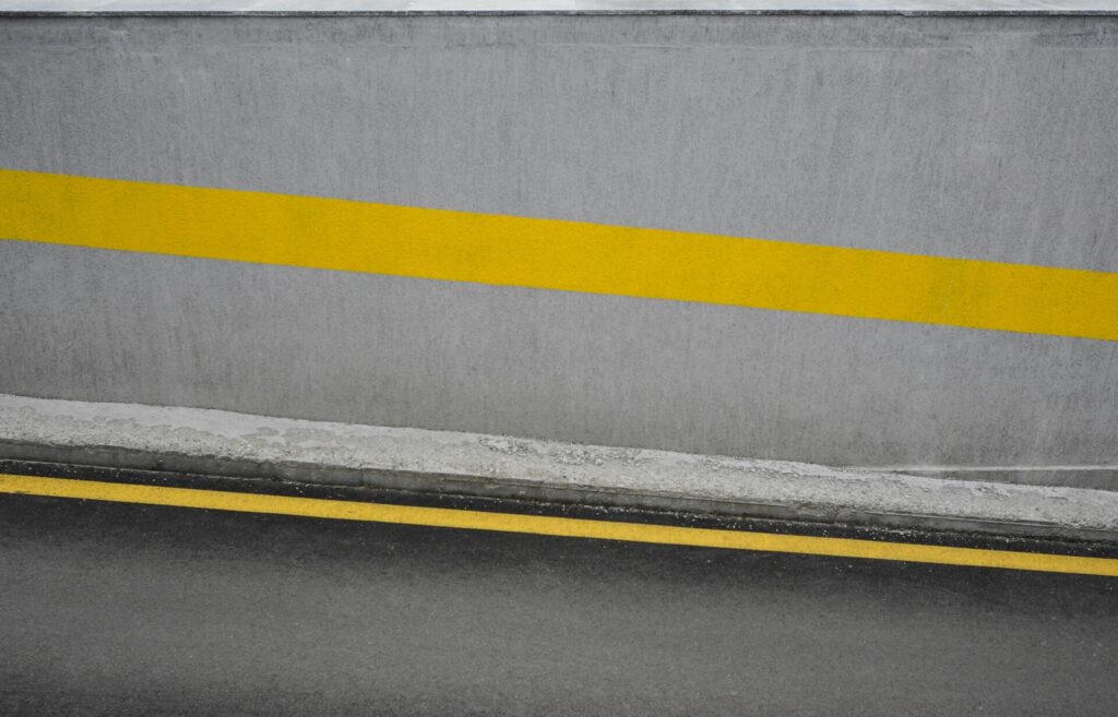 A concrete surface with two yellow lines running parallel to each other.