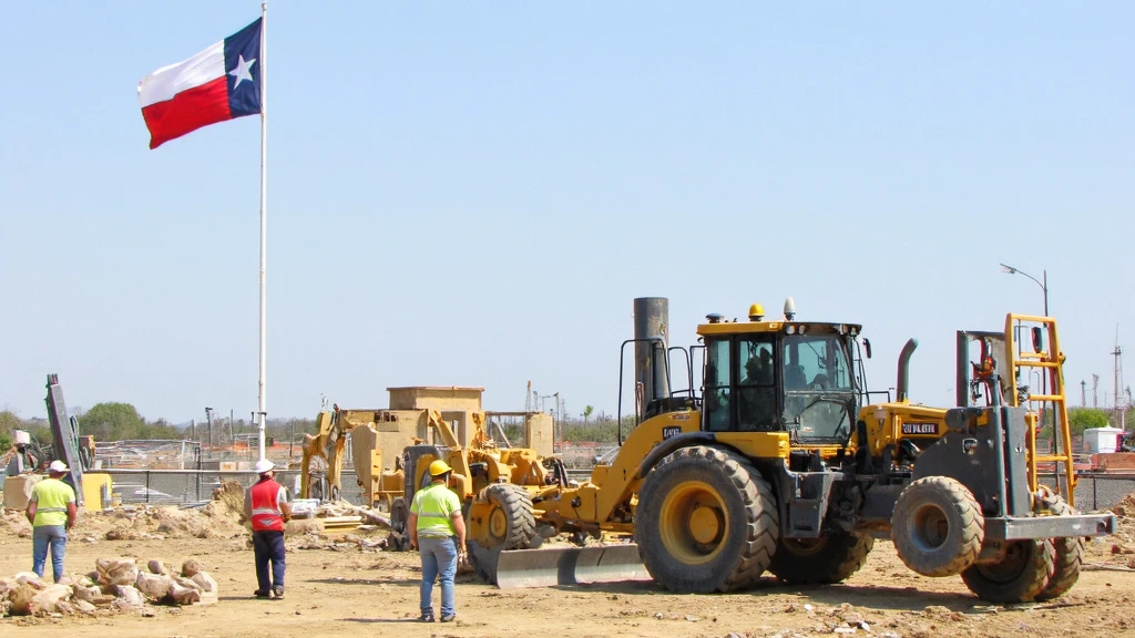 Texas Flag at Construction Site Texas flag waving near a modern construction site with workers and robots working side by side