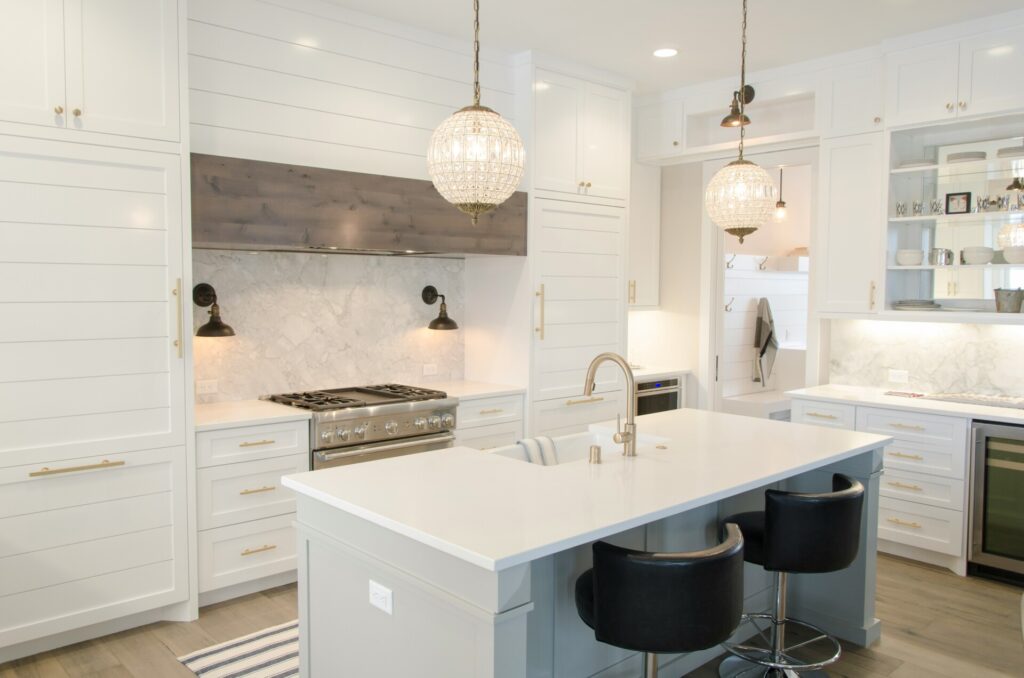 A modern kitchen with white cabinets and large island countertop.