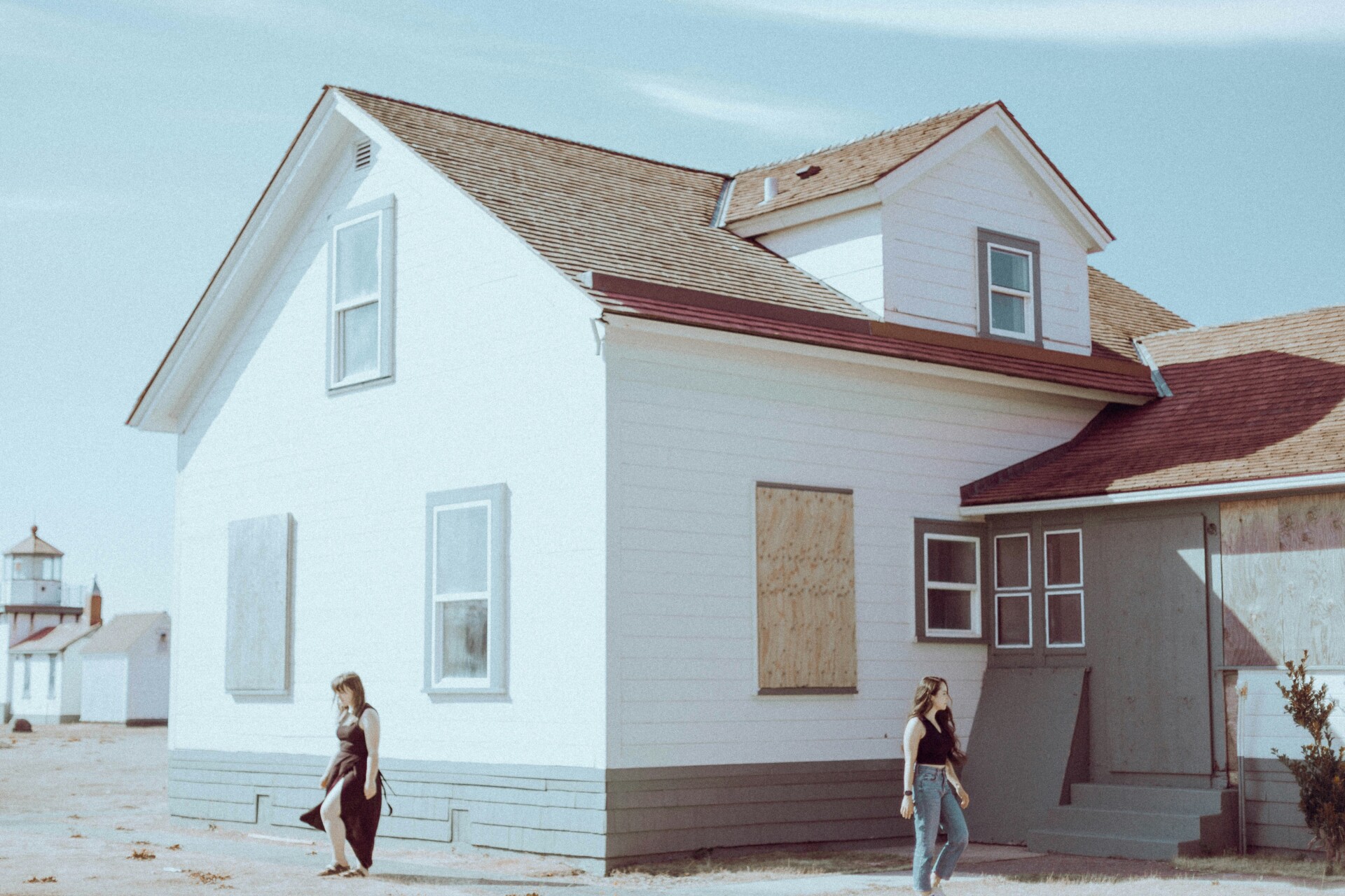 Abandoned House Exploration Two people walking near an abandoned house with boarded windows.