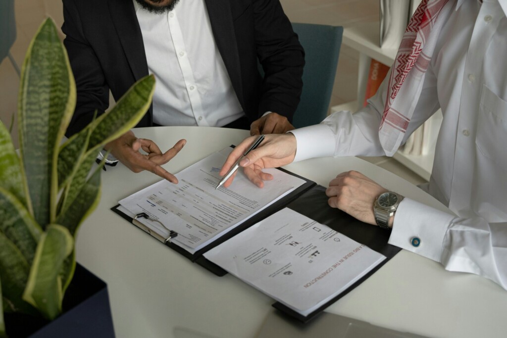 Two individuals reviewing documents during a business meeting.