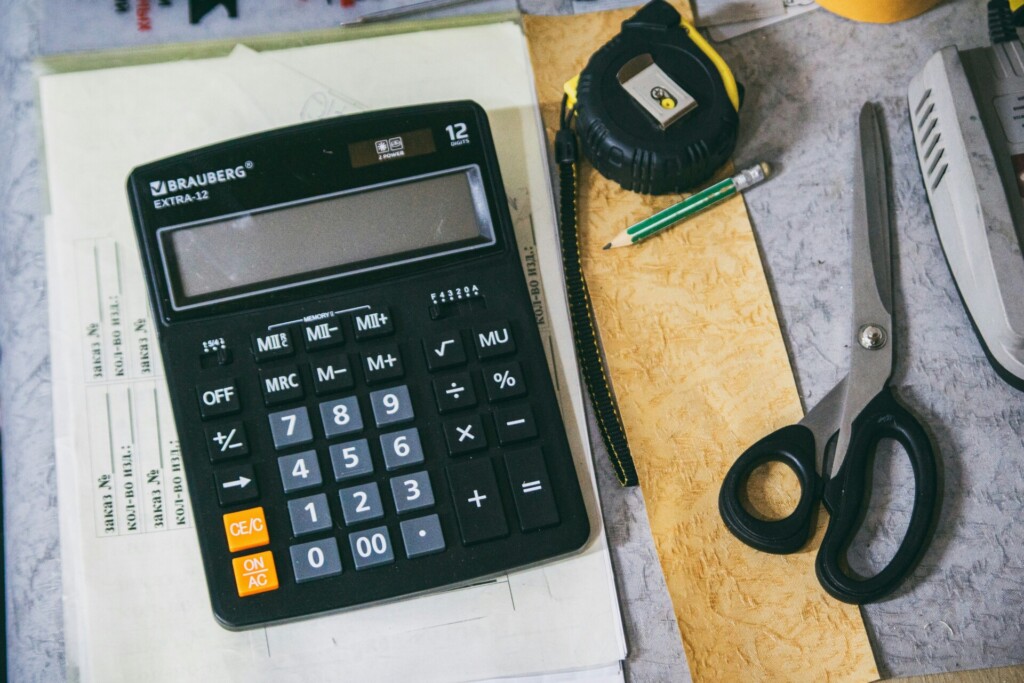 Tools of the Trade: Calculator and Crafting Essentials A calculator, scissors, measuring tape, and stationery on a workspace.