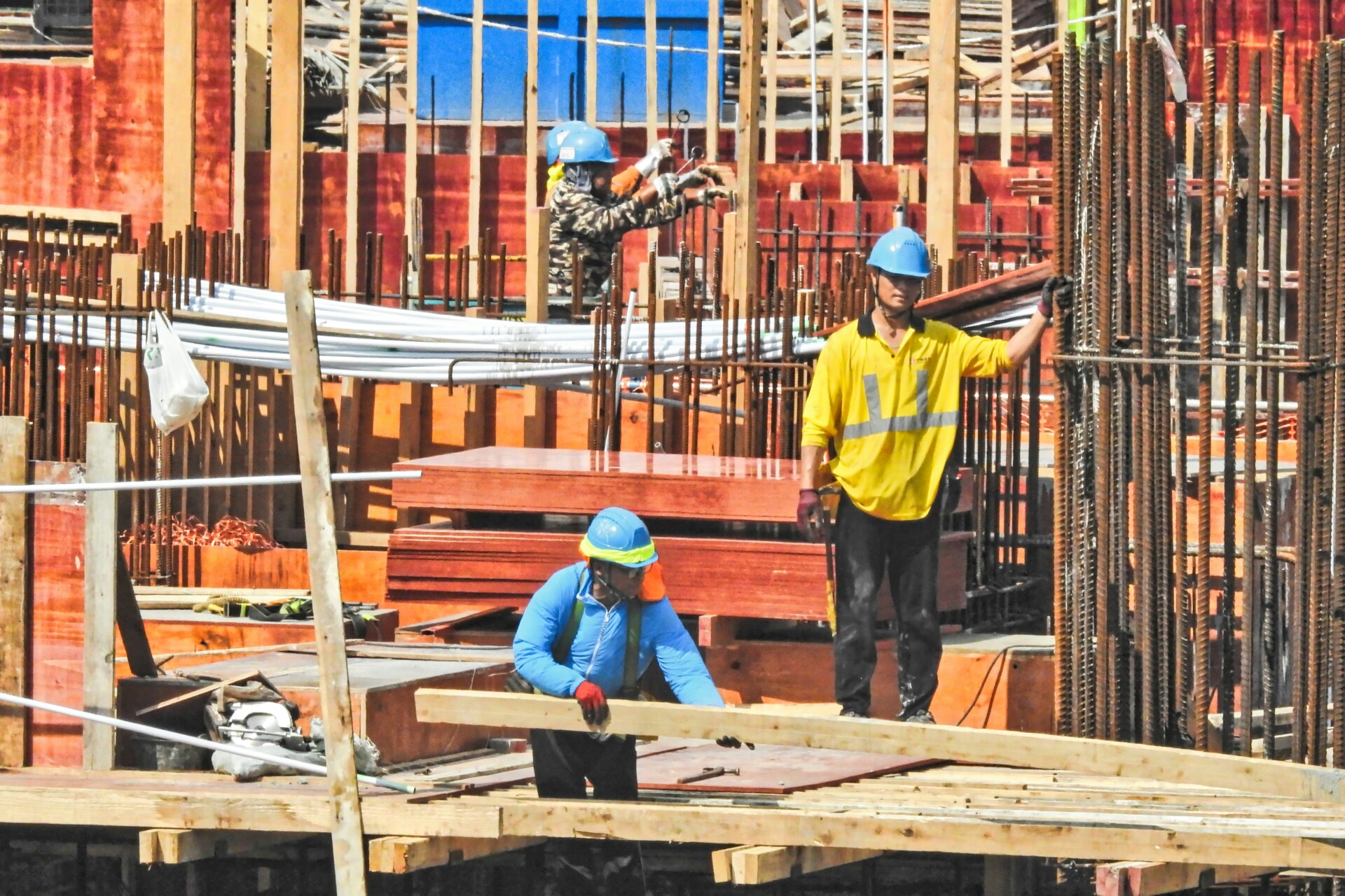 Construction at Work Three construction workers actively working on a building site