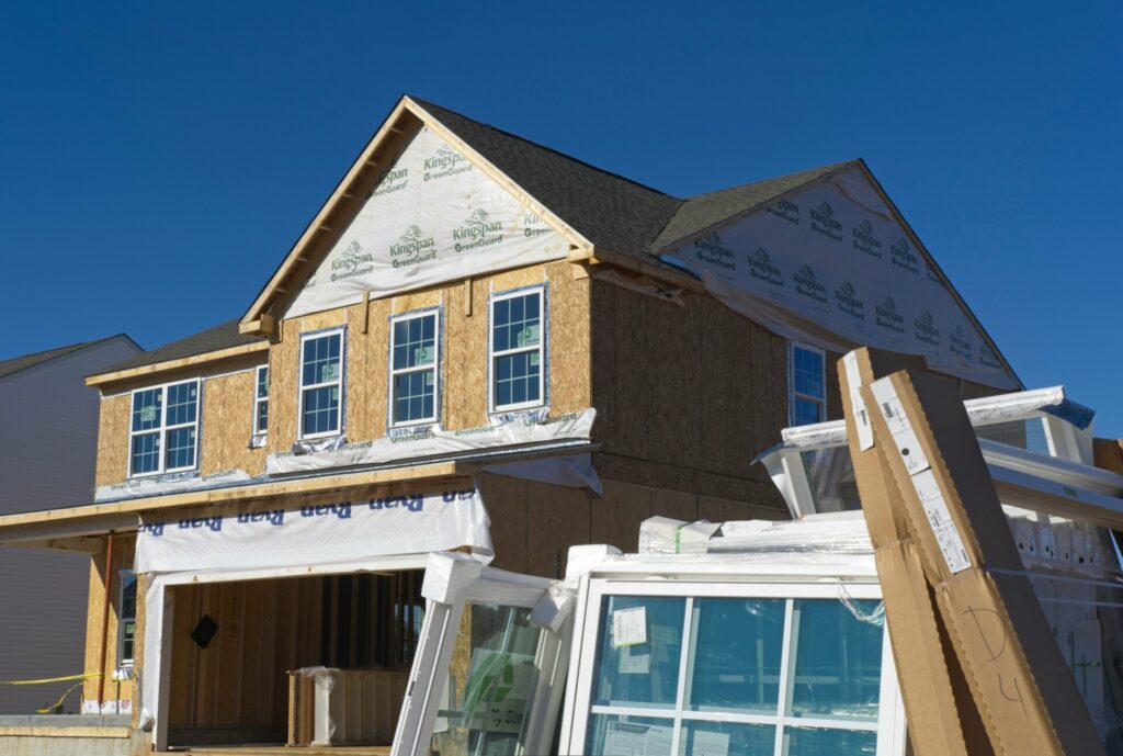 A two-story house under construction with blue sky in the background.