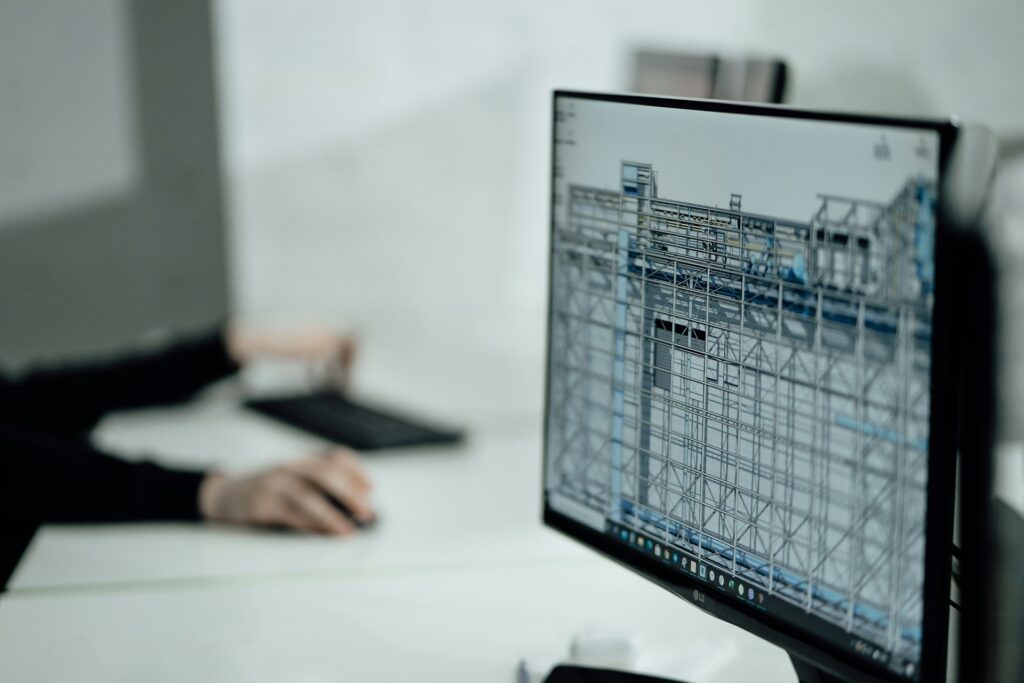 Person works on architectural design software displayed on a computer monitor.