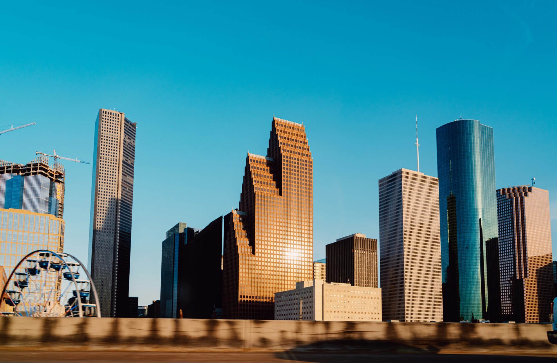 Houston Skyline at Sunset View of Houston's skyline featuring various modern buildings against a clear blue sky.