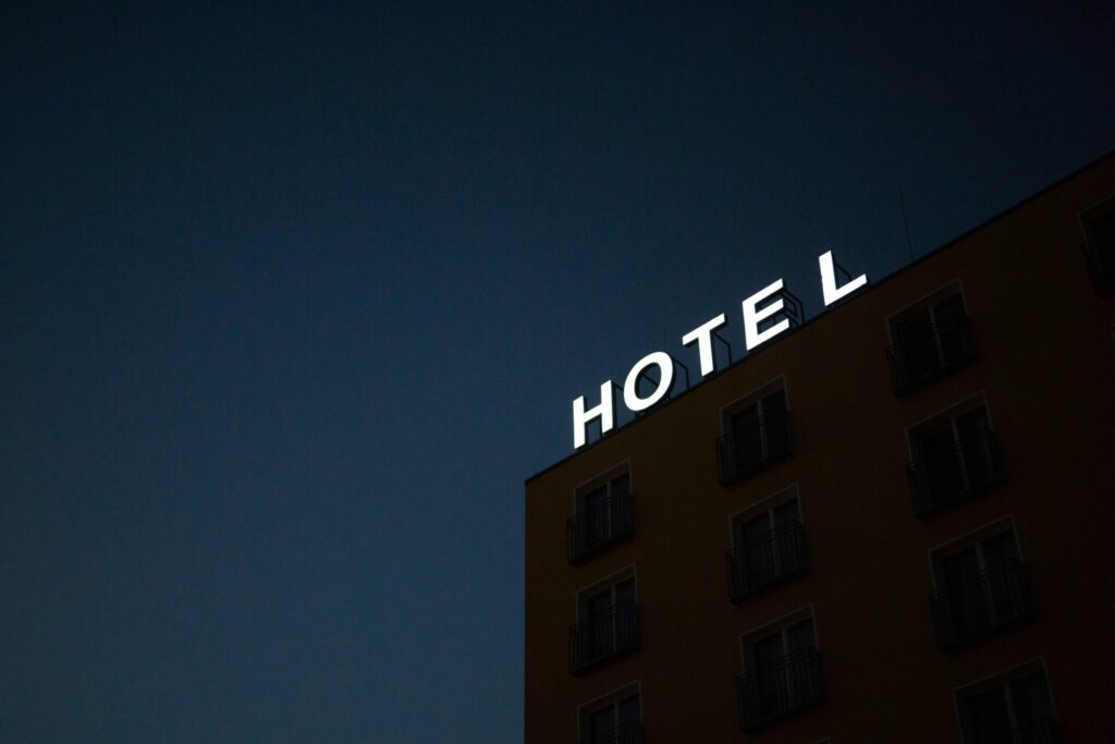 A hotel sign glows at night against a deep blue sky.