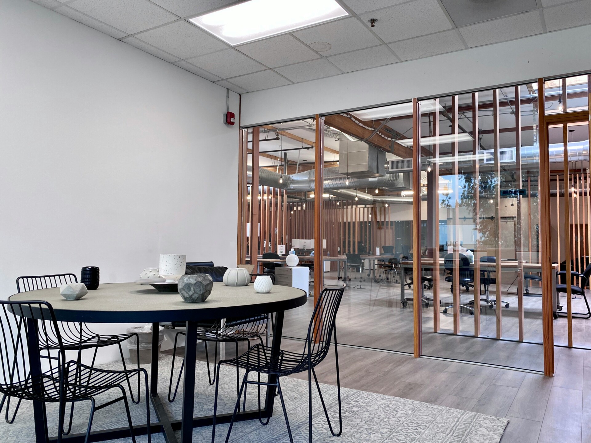 Contemporary Office Interior Design A modern office space featuring a round table with decorative items and a glass-walled meeting room.
