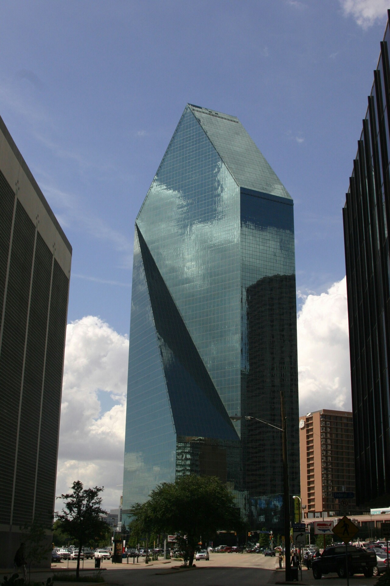Reflection in a Modern Skyscraper Tall, modern glass building reflecting clouds and adjacent structures.