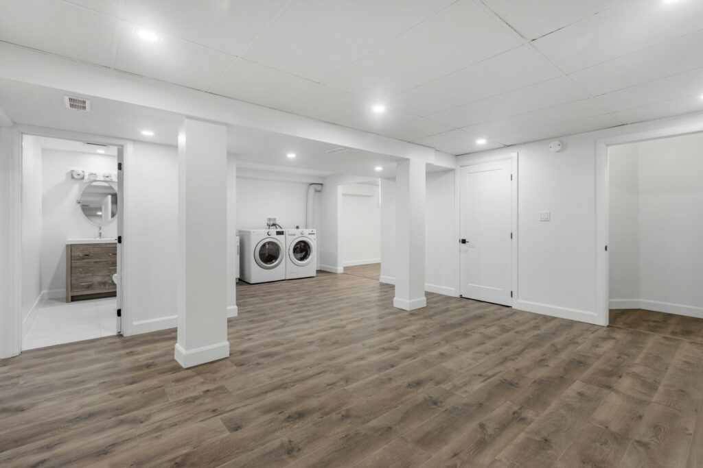 Modern basement with hardwood floors, laundry area, and recessed lighting.