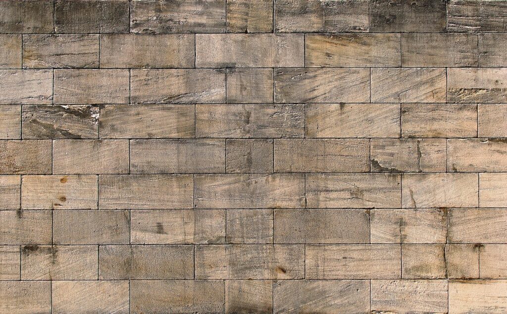 Stone wall with rectangular bricks showing weathered texture and neutral colors.