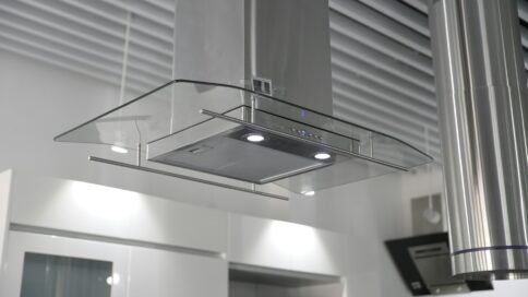 A stainless steel kitchen extractor hood with lights in a modern setting.