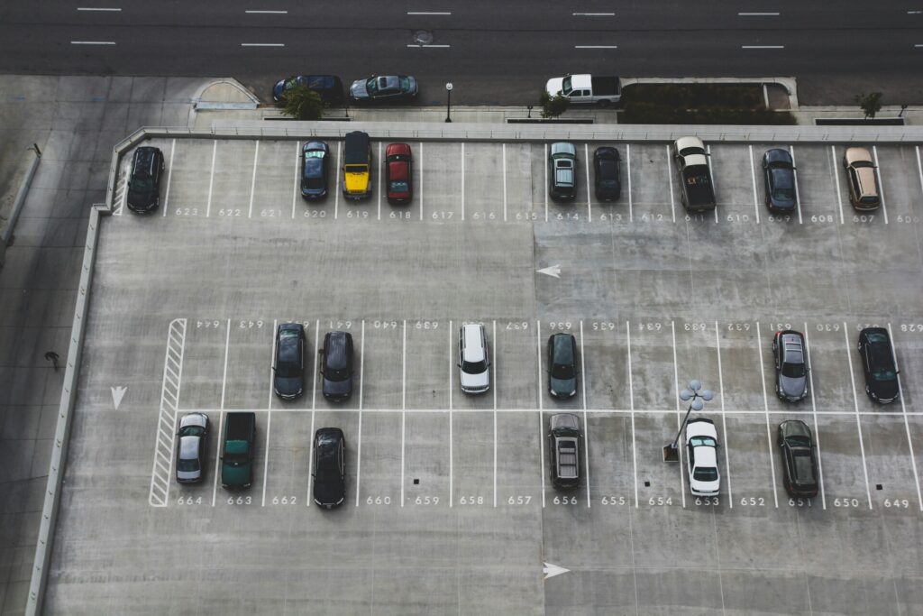 Aerial view of a nearly empty parking lot with scattered parked cars.