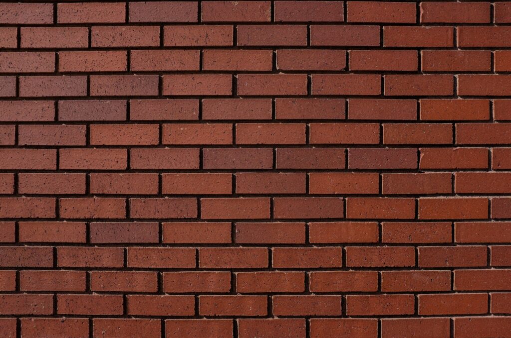 Red brick wall with evenly stacked horizontal rows of bricks.