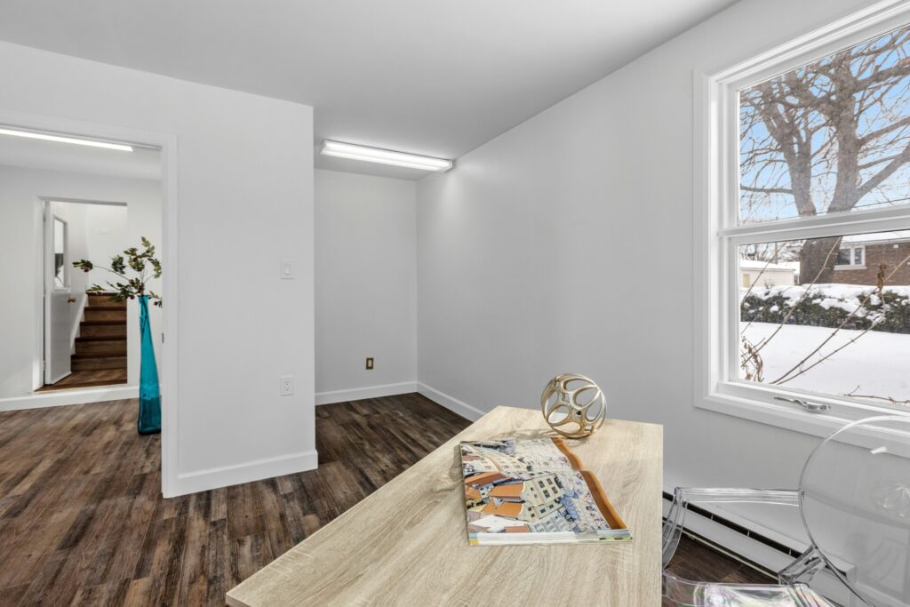 A bright room with a wooden desk, window view, and decorative items.