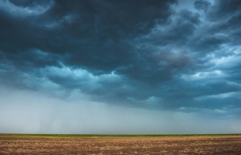 Dark storm clouds hovering over a vast, barren landscape.