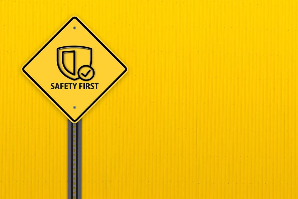Yellow safety sign with "Safety First" against a matching yellow background.