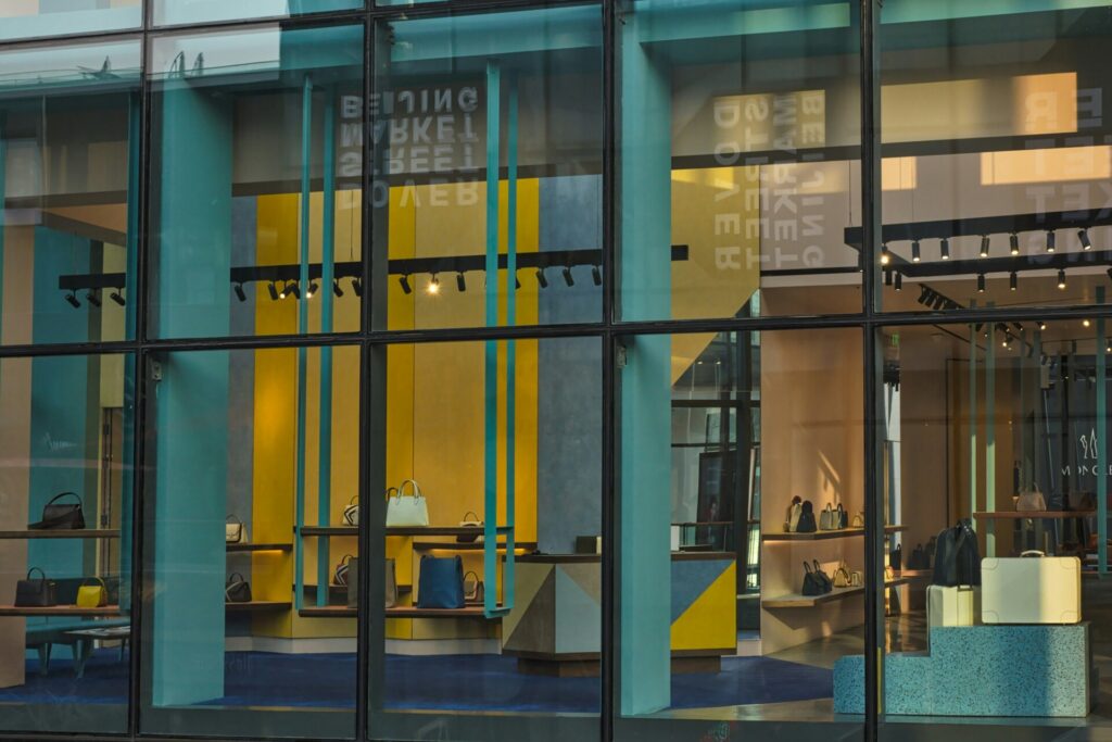 A modern store display with colorful handbags and geometric design elements.