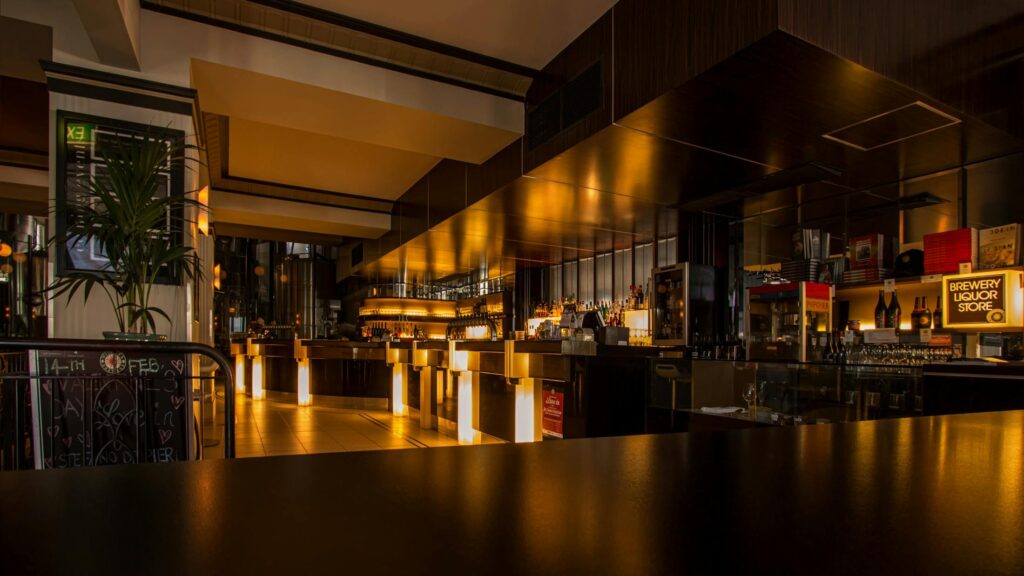 A dimly lit modern bar with warm lighting and sleek design.