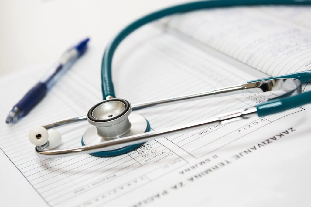 A stethoscope and pen rest on an open medical document.