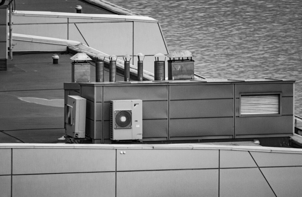 Black and white image of rooftop HVAC systems on a modern building.