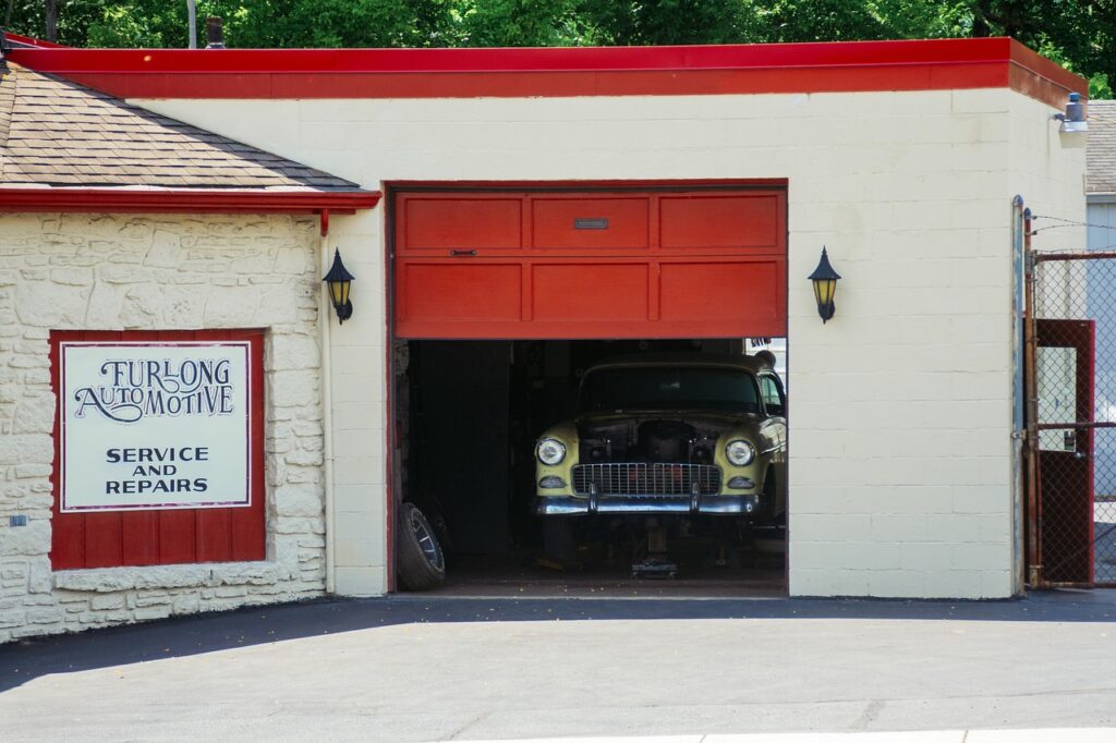 Vintage car inside a garage with signage for Furlong Automotive Service.