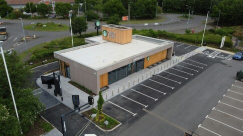 Aerial view of a Starbucks drive-thru next to a roundabout with parking spaces.