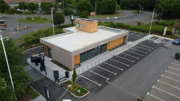 Aerial view of a Starbucks drive-thru next to a roundabout with parking spaces.