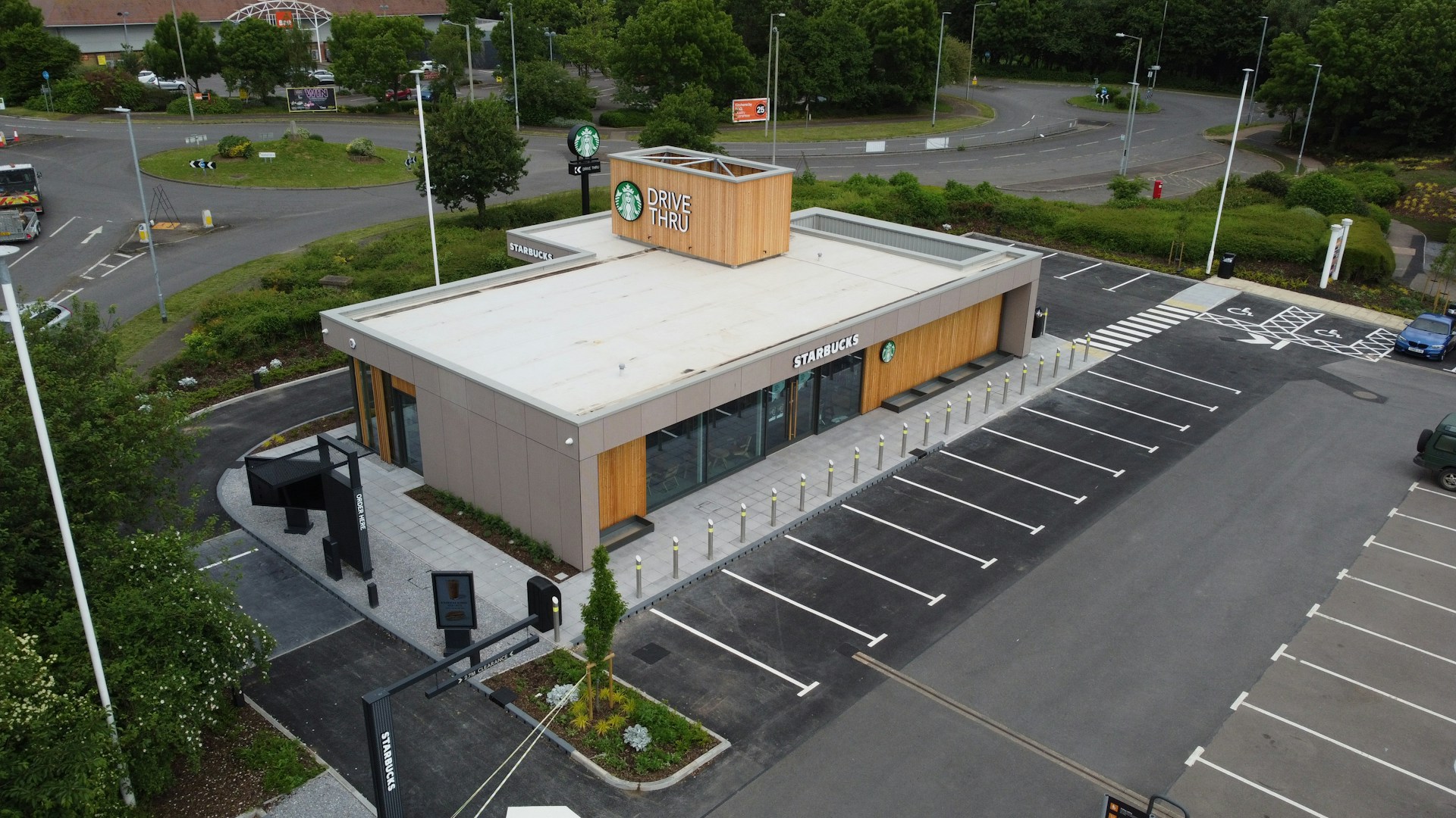 Aerial view of a Starbucks drive-thru next to a roundabout with parking spaces.