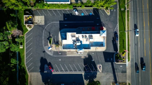 Aerial view of a small parking lot surrounding a single-story building.