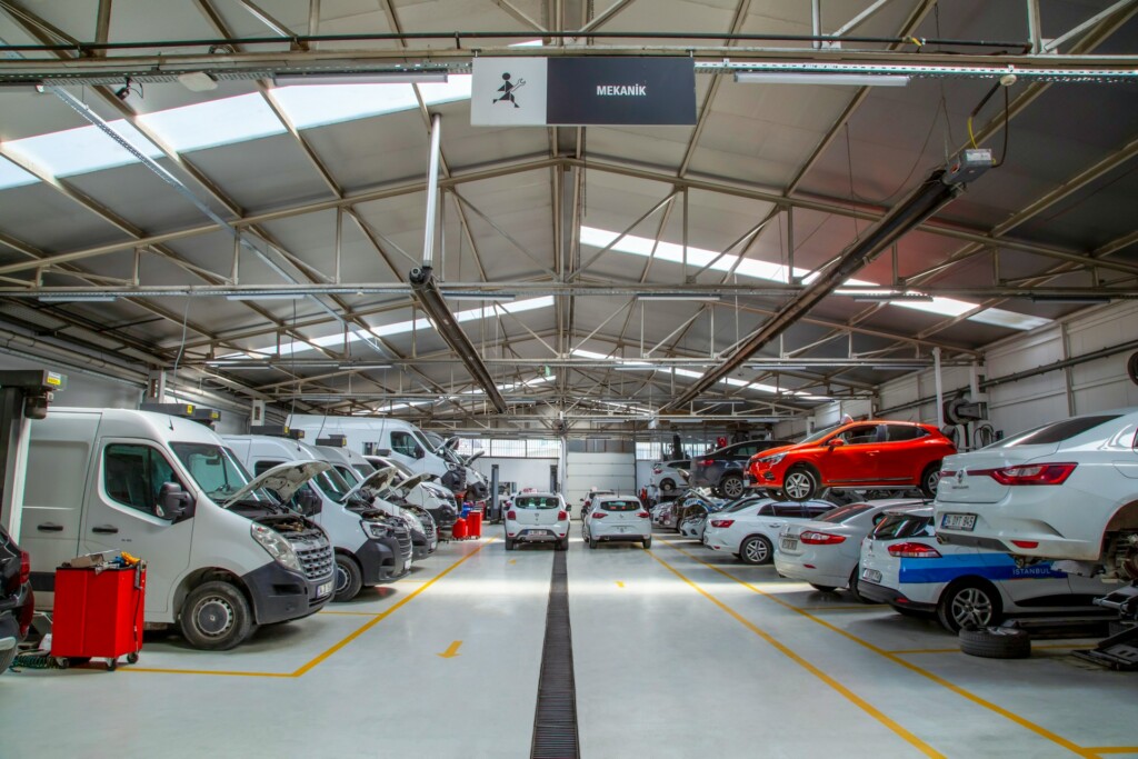 A busy automotive service center with cars and vans, some on lifts.