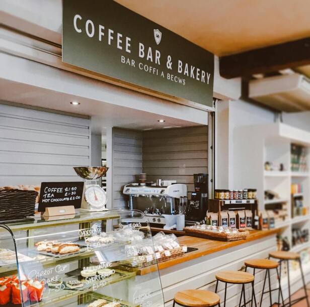 A cozy coffee bar and bakery counter displaying drinks and pastries.