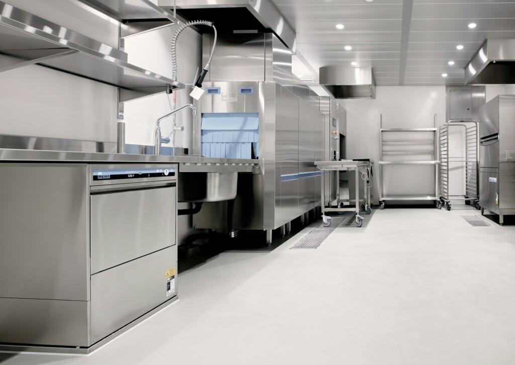 Modern commercial kitchen with stainless steel appliances and industrial design.