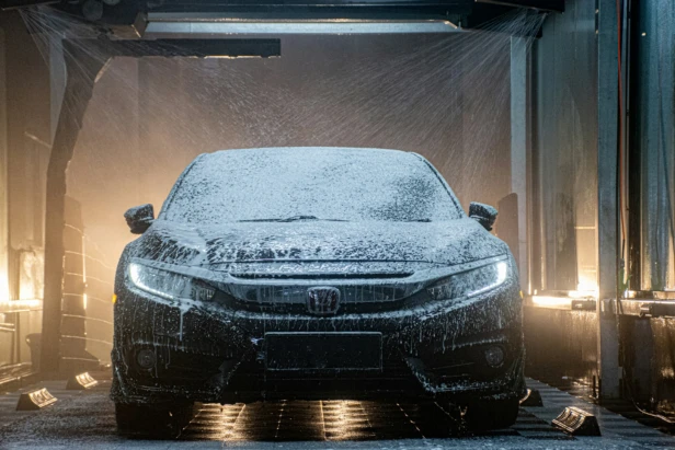A car being washed with soap in an automated car wash.