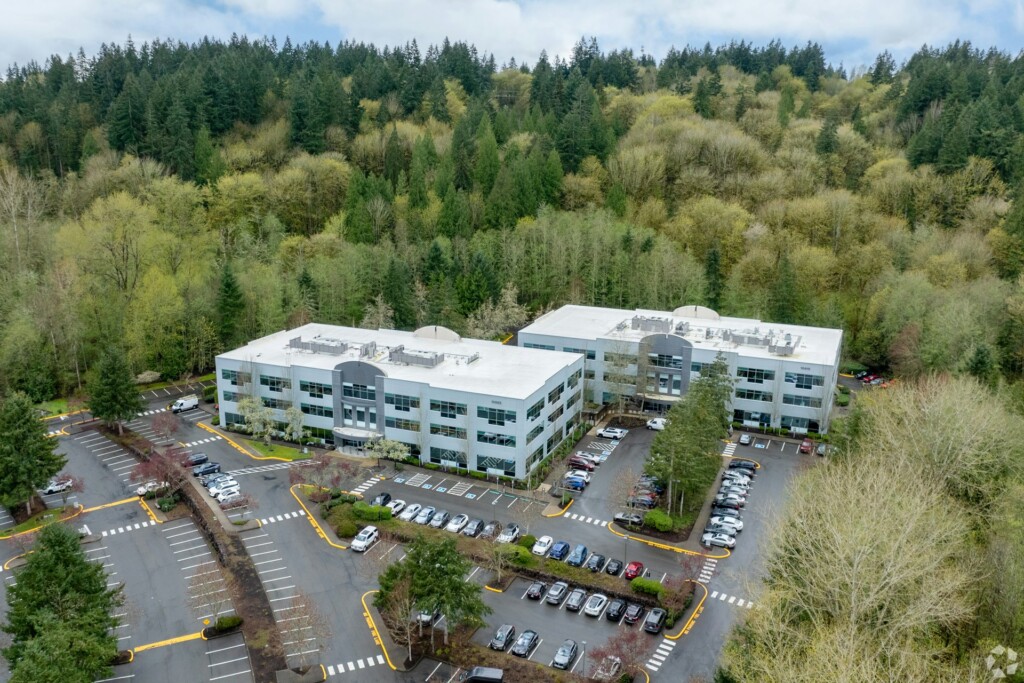 Aerial view of two office buildings surrounded by a forested landscape.
