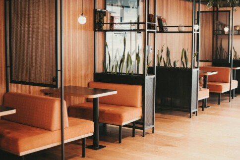 Cozy modern café interior with orange booths and wooden accents.