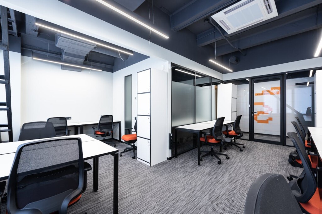 Modern office space with desks, chairs, and contemporary lighting.