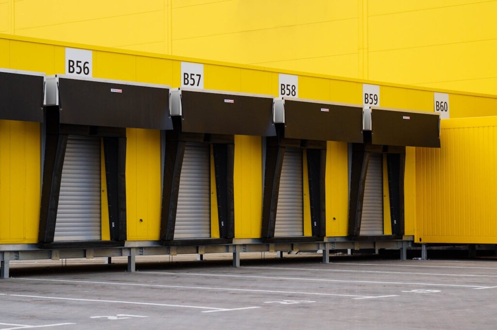 Bright yellow warehouse loading docks with numbered black awnings.