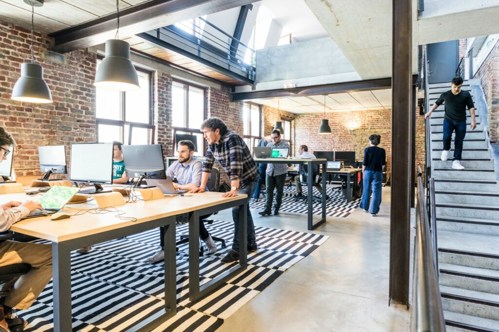 Modern open-plan office with people working at desks and computers.