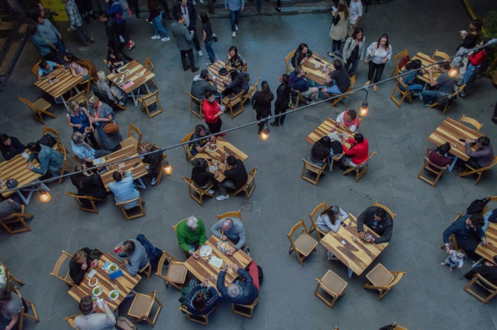 Aerial view of people dining at tables in an open restaurant setting.