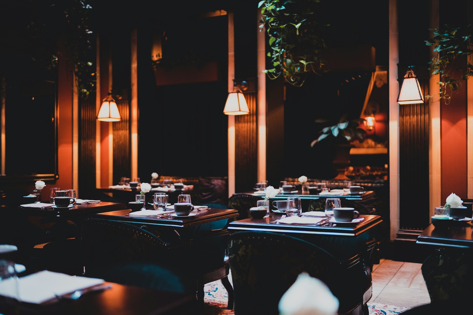 A dimly lit restaurant with elegant dark wood tables and ambient lighting.