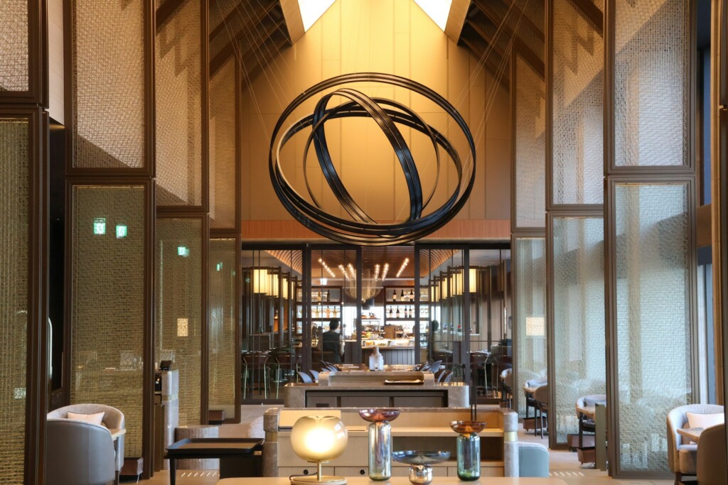 Modern interior with geometric chandelier and elegant furnishings under warm lighting.